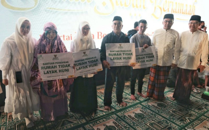 BANTUAN. Baznas Kota Makassar melalui Wali Kota Makassar, Moh Ramdhan Pomanto (kedua kanan), menyerahkan bantuan perbaikan Rumah Tidak Layak Huni (Rutilahu) kepada empat warga Kota Makassar di Anjungan City of Makassar, Pantai Losari Makassar, Sabtu (5/11/2022). foto: istimewa