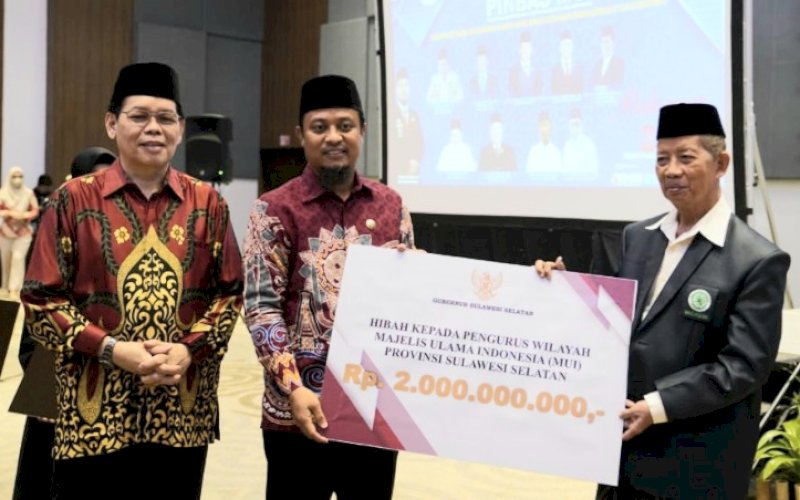 PENYERAHAN. Gubernur Sulsel, Andi Sudirman Sulaiman menyerahkan bantuan hibah kepada Ketua MUI Sulsel AG Prof DR KH Najamuddin Abd Safa LC MA di Four Points by Sheraton Makassar, Minggu (4/12/2022). foto: istimewa