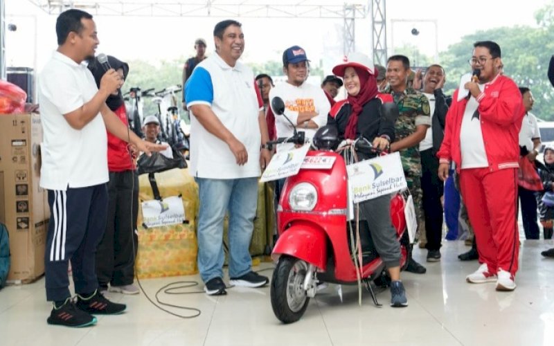 JALAN SEHAT. Gubernur Sulsel, Andi Sudirman Sulaiman, menyerahkan bantuan dan hadiah kepada masyarakat pada Jalan Sehat Anti Mager dalam rangka Hari Kesehatan Nasional Tingkat Provinsi di Lapangan Pallantikang, Kabupaten Maros, Sabtu (24/12/2022). foto: istimewa