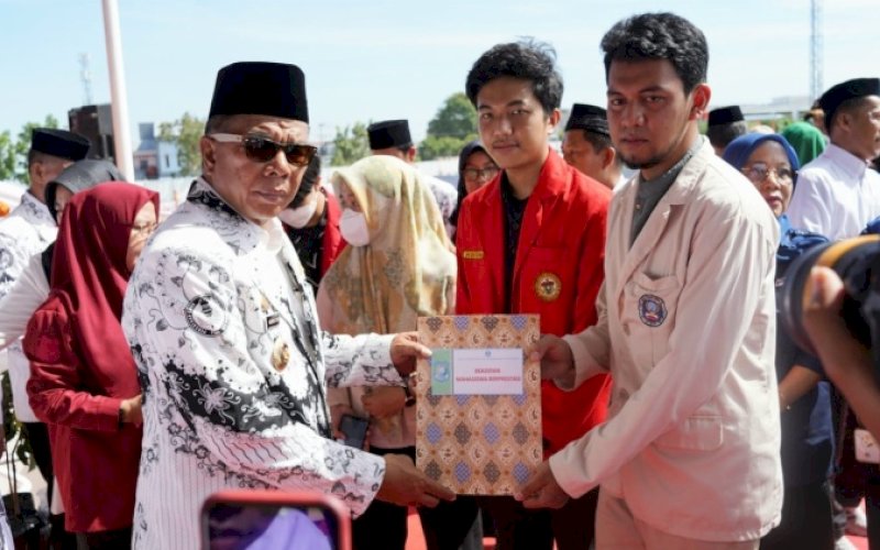 BANTUAN BERPRESTASI. Bupati Bulukumba, Andi Muchtar Ali Yusuf, secara simbolis menyerahkan bantuan beasiswa berprestasi di sela-sela upacara peringatan HUT PGRI Ke-77 di Stadion Mini Bulukumba, Rabu (21/12/2022). foto: istimewa