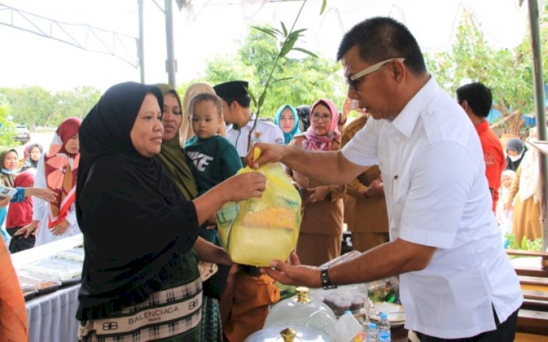 BERBAGI. Bupati Bulukumba, Andi Muchtar Ali Yusuf, memberikan bingkisan kepada salah seorang orang tua di sela-sela melaunching 'Gempur Stunting' atau Gerakan Masyarakat untuk Penanganan Urusan Stunting di halaman Kantor Camat Gantarang, Selasa (27/12/2022). foto: istimewa