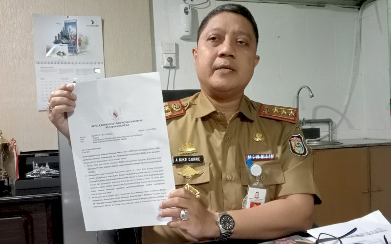 LEGALITAS. Kepala Balitbangda Kota Makassar, Andi Bukti Djufrie memperlihatkan surat keputusan (SK) BRIN terkait peralihan Balitbangda Makassar jadi Brida, di Balaikota, Jumat (2/12/2022). foto:istimewa