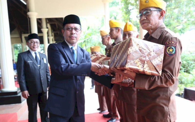 PEDULI. Sekda Kota Makassar, Muh Ansar, menyerahkan bantuan dan bingkisan kepada puluhan legiun veteran yang menjadi saksi hidup dalam peristiwa korban 40 ribu jiwa pada upacara peringatan peristiwa Korban 40 Ribu Jiwa Ke-76 Tahun di Monumen Korban 40 Ribu Jiwa, Jl Langgau, Kecamatan Tallo, Kota Makassar, Minggu (11/12/2022). foto: istimewa