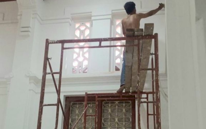 PENGECETAN. Seorang pekerja melakukan pengecetan pada proyek konstruksi revitalisasi Gedung Cagar Budaya Kantor Pengadilan Negeri (PN) Makassar. foto: istimewa