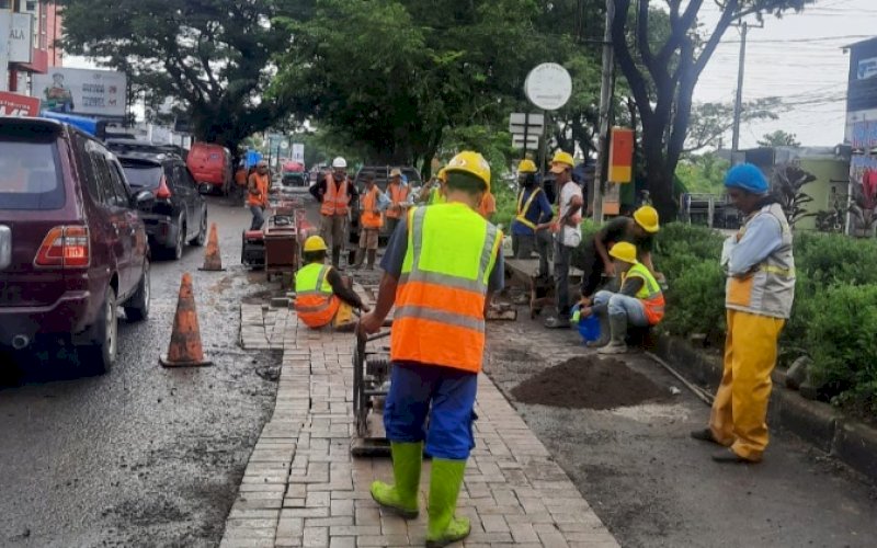 PENGERJAAN. Pekerja melakukan penanganan darurat pada ruas Jalan Aroepala atau biasa disebut Jalan Hertasning, Kota Makassar. foto: istimewa