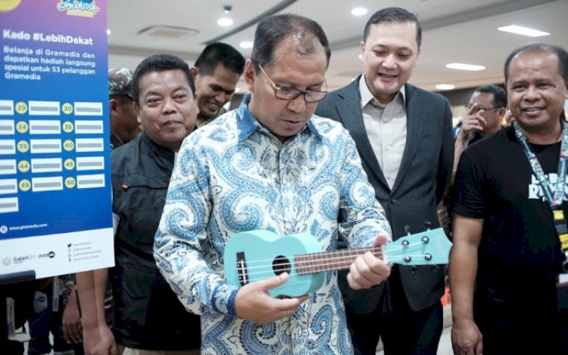 MAIN GITAR. Wali Kota Makassar, Moh Ramdhan Pomanto, main gitar mini, di sela-sela meresmikan Gramedia Store Pettarani, Kamis (2/2/2023). foto: istimewa