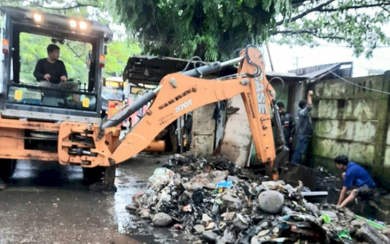 PEMBERSIHAN. Dinas PUTR Provinsi Sulsel melakukan pembersihan saluran drainase di Jl Letjend Hertasning, Kota Makassar, Rabu (1/2/2022). foto: istimewa