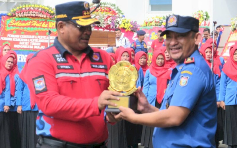 PENYERAHAN. Penyerahan piala bergilir dari Kepala Damkar Kota Makassar, Hasanuddin (kanan) ke Dirjen Administrasi Kewilayahan Kemendagri RI Syafrizal. foto: istimewa