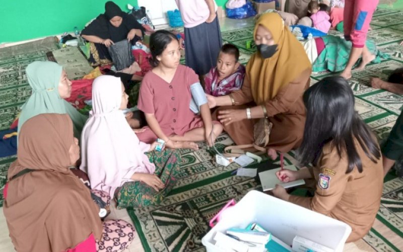 LAYANAN KESEHATAN. Dinas Kesehatan Kota Makassar memberikan pelayanan kesehatan kepada korban terdampak banjir di posko pengungsian. foto: istimewa