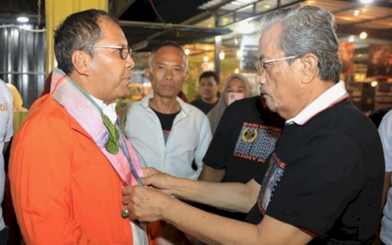 SAMBUTAN. Tokoh adat Kecamatan Ajangale, Kabupaten Bone Andi Amiruddin mengalungkan sarung sutra kepada Wali Kota Makassar Moh Ramdhan Pomanto, saat menghadiri silaturahmi Mappasiduppa Mata dengan tokoh masyarakat se-Bone Utara di Cafe Kampoeng Kreatif Pompanua yang berlokasi di Lapangan Dulungna Ajangale, Kabupaten Bone, Minggu (26/2/2023). foto: istimewa