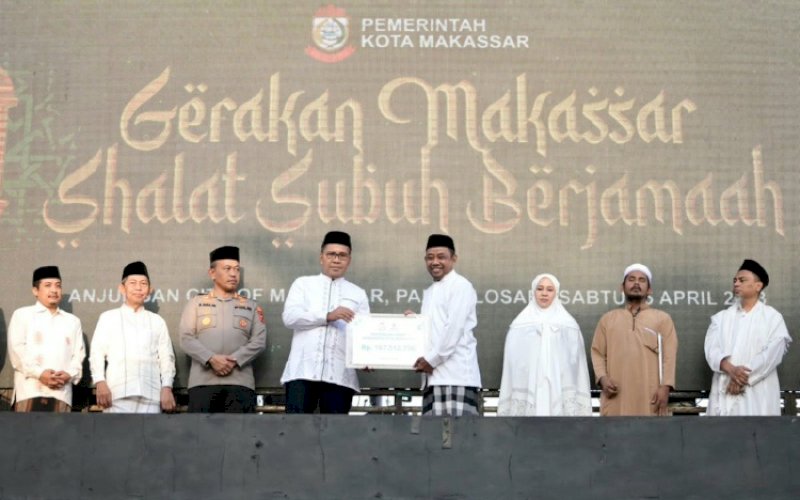 PENYERAHAN. Wali Kota Makassar, Moh Ramdhan Pomanto, menyerahkan zakat mal atau harta lewat Baznas Kota Makassar di sela-sela pelaksanaan Gerakan Makassar Salat Subuh Berjemaah (GMSSB) di Anjungan Pantai Losari Makassar, Sabtu (15/4/2023). foto: istimewa