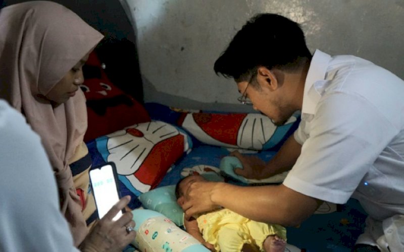 PEDULI. Ketua Forum Kemanusian Kota Makassar (FKKM), dr Udin Shaputra Malik, melihat kondisi bayi yang sedang sakit di Jl Sanrangan 4 ,depan Masjid Nurul Yasin, Kelurahan Sudiang Raya, Kecamatan Biringkanaya, Sabtu (6/5/2023). foto: istimewa