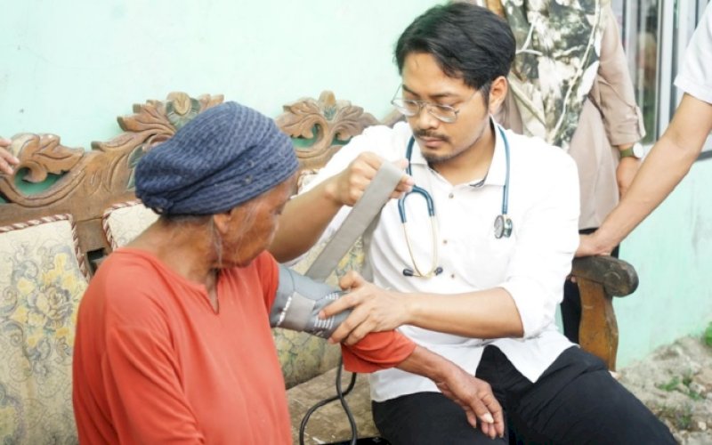 PEMERIKSAAN. Ketua FKKM, dr Udin Shaputra Malik, memeriksa salah seorang lansia di Kelurahan Bira, Kecamatan Tamalanrea, Kota Makassar, akhir Mei 2023 lalu. foto: istimewa