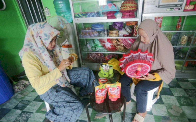 KERAJINAN. Syamsiah didampingi Bendahara Kelompok Usaha Ratu Tamalabba tengah membuat kerajinan tangan dari daur ulang sampah plastik. foto: istimewa