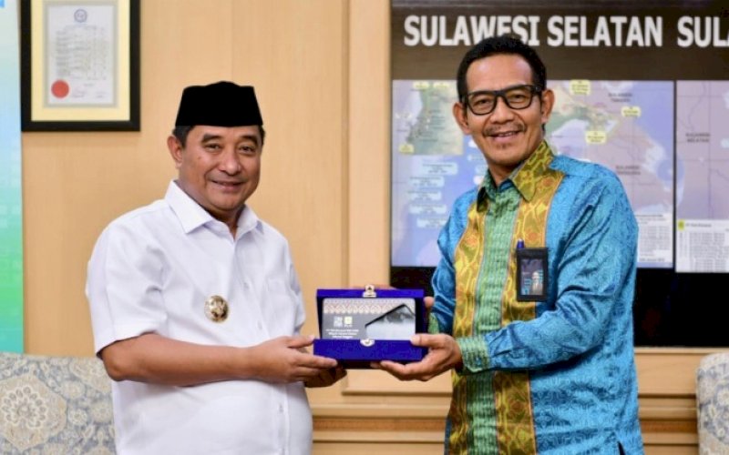 PERTEMUAN. Penjabat (Pj) Gubernur Sulsel Bahtiar Baharuddin bertukar cendera mata dengan General Manager PLN Unit Induk Distribusi Sulselrabar Moch Andy Adchaminoerdin pada pertemuan di Kantor PLN Wilayah Sulselrabar, Jl Letjen Hertasning, Kota Makassar, Jumat (15/9/2023) sore. foto: istimewa