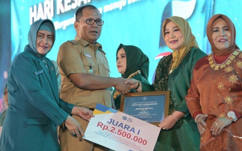 PENGHARGAAN. Ketua TP PKK Kota Makassar Indira Jusuf Ismail dan Wali Kota Makassar Moh Ramdhan Pomanto penghargaan dalam acara seremonial di UpperHills Convention Hall Makassar, Senin (16/10/2023). foto: istimewa