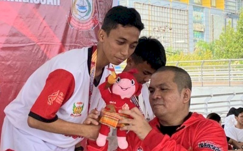 SANG JUARA. Ketua Umum Perkemi Kota Makassar, dr Wachyudi Muchsin, menyerahkan medali kepada juara cabor kempo pada Porkot VIII Makassar 2023 di Tribun Karebosi Makassar, Senin (23/10/2023). foto: istimewa