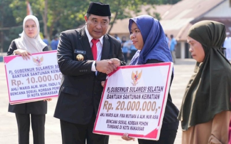 BANTUAN. Pj Gubernur Sulsel, Bahtiar Baharuddin, menyerahkan bantuan sosial usai memimpin upacara peringatan Hari Pahlawan yang dilaksanakan di Taman Makam Pahlawan, Panaikang, Kota Makassar, Jumat (10/11/2023).&nbsp;foto: istimewa