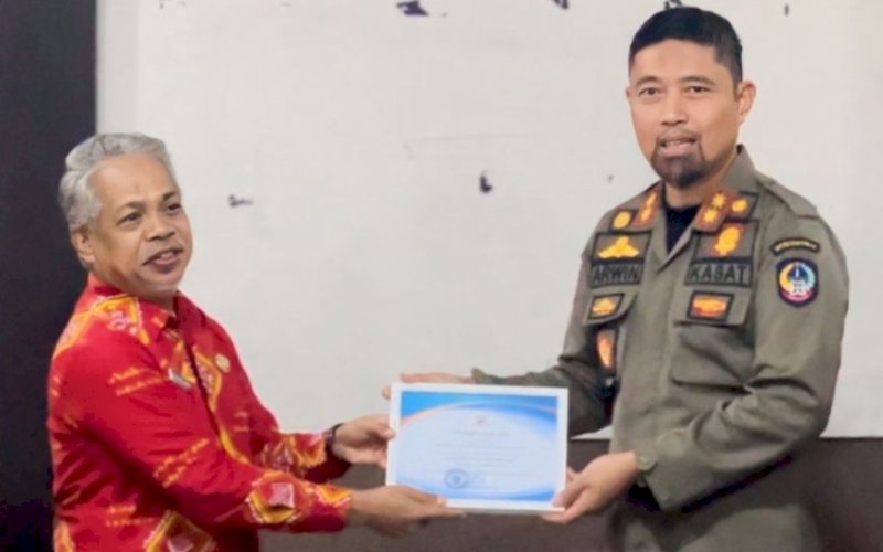 PENGHARGAAN. Dinas Perpustakaan dan Kearsipan Provinsi Sulsel yang diserahkan Kepala Dinas Perpustakaan dan Kearsipan Sulsel diwakili Kepala Bidang Kearsipan Muhlis Mallajareng menyerahkan penghargaan kepada Kasatpol PP Sulsel Andi Arwin Azis (kanan), Kamis (14/12/2023). foto: istimewa.