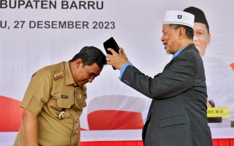 SOWAN. Pimpinan Ponpes DDI Mangkoso AGH Farid Wajdi Lc MA memberikan dan memasangkan songkok atau kopiah kepada Pj Gubernur Bahtiar Baharuddin Ponpes DDI Mangkoso, Kampus II Putra Tonrongnge, Kiru-kiru, Soppeng Riaja, Barru, Rabu (27/12/2023). foto: istimewa