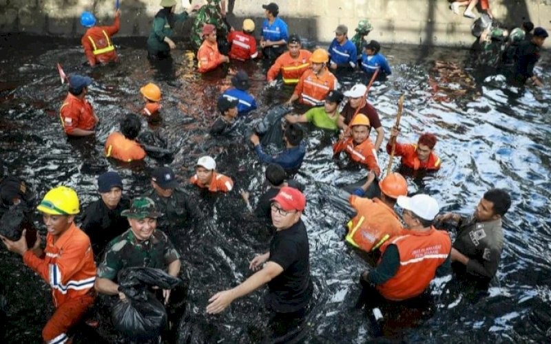 BERSIH KANAL. Wali Kota Makassar, Moh Ramdhan Pomanto (topi merah), turun langsung ke kanal melakukan aksi bersih-bersih kanal, Sabtu (9/12/2023) pagi. foto: istimewa
