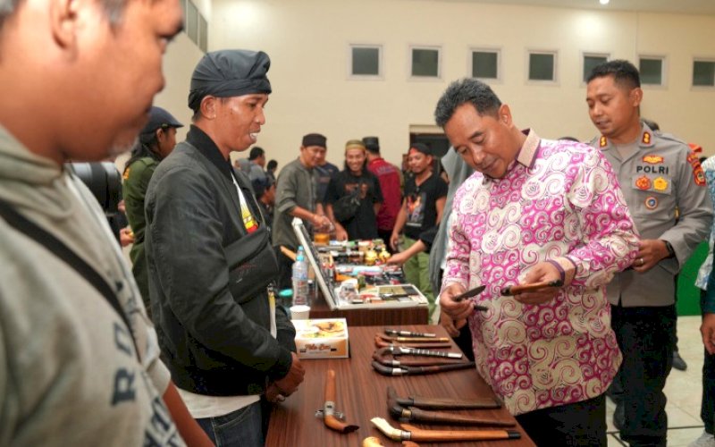 BADIK. Pj Gubernur Sulsel, Bahtiar Baharuddin, mengamati sebilah badik pada Mulo Kreatif Kolaborasi 2024, yang diselenggarakan Dinas Kebudayaan dan Pariwisata Sulsel, di Gedung Mulo Makassar, Jumat (19/1/2024) malam. foto: istimewa