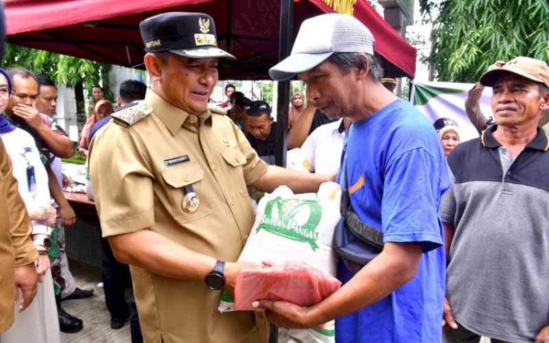 BANTUAN PANGAN. Pj Gubernur Sulsel, Bahtiar Baharuddin, menyerahkan bantuan pangan pada acara Pasar Murah dan Launching Bantuan Pangan, di Halaman Kantor Camat Bantimurung, Kabupaten Maros, Selasa (30/1/2024). foto: istimewa