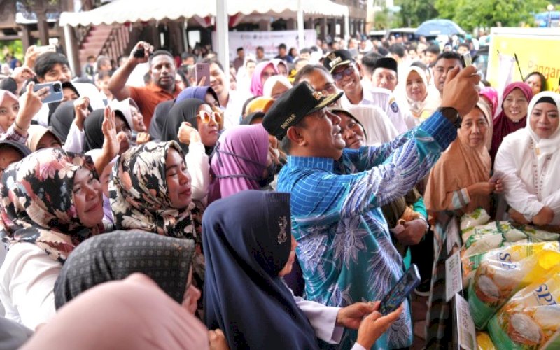 SWAFOTO. Pj Gubernur Sulsel, Bahtiar Baharuddin, swafoto bersama warga di sela-sela menyalurkan bantuan pangan dari pemerintah pusat di Kabupaten Takalar, Rabu (31/1/2024). foto: istimewa