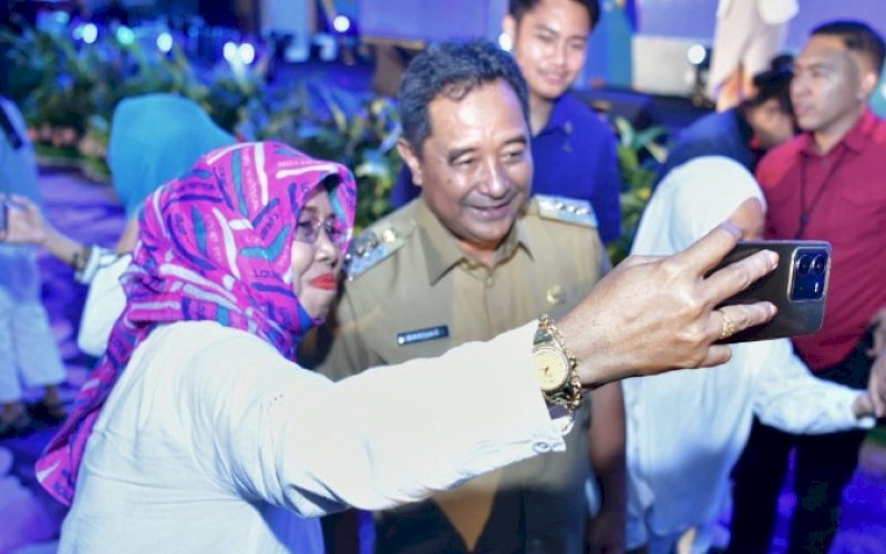 SWAFOTO. Seorang ibu swafoto bersama Pj Gubernur Sulsel, Bahtiar Baharuddin, di sela-sela kegiatan Literasi Digital untuk Pemilu Damai di Makassar dengan tema Cerdas Memilih, Bijak Berkreasi, di Upperhills Convention Makassar, Kamis (1/2/2024). foto: istimewa