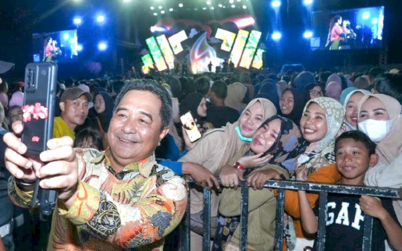 SWAFOTO. Pj Gubernur Sulsel, Bahtiar Baharuddin, swafoto bersama warga yang memadati Malam Hiburan Peringatan Hari Ulang Tahun (HUT/Hari Jadi) Bulukumba ke-64 yang menghadirkan artis ibu kota Armada Band di Stadion Mini Bulukumba, Minggu (4/2/2024) malam. foto: istimewa