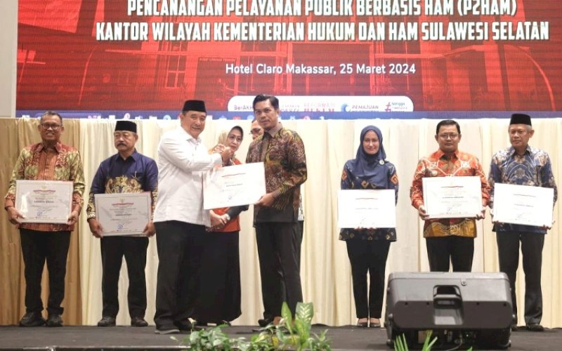 PENGHARGAAN. Pj Gubernur Sulsel Bachtiar Baharuddin menyerahkan penggargaan kepada Pj Sekda Kota Makassar Firman Hamid Pagarra yang diraih Pemkot Makassar sebagai Kota Peduli HAM dalam rangkaian peringatan Hari HAM Sedunia ke-75 tahun 2023 di Hotel Claro Makassar, Senin (25/3/2024). foto: istimewa