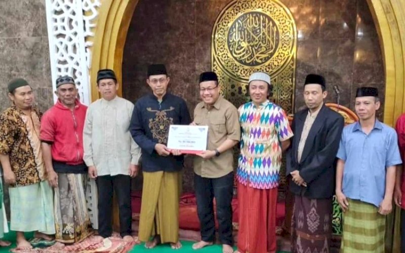 PENYERAHAN. Sekwan DPRD Kota Makassar, Dahyal, menyerahkan bantuan dana hibah Pemkot Makassar kepada pengurus Masjid Jannatul Firdaus Biring Romang, Kecamatan Manggala, Kota Makassar, Jumat (22/3/2024). foto: istimewa