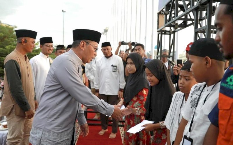 BERI SANTUNAN. Wali Kota Makassar, Moh Ramdhan Pomanto, memberikan santunan kepada anak yatim piatu pada buka puasa bersama di Anjungan Pantai Losari Makassar, Jumat (22/3/2024). foto: istimewa