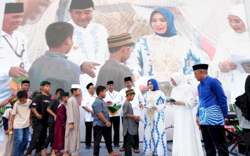 SANTUNAN. Pj Ketua TP PKK Sulsel Sofha Marwah Bahtiar mendampingi Pj Gubernur Sulsel Bahtiar Baharuddin menyerahkan santunan untuk anak yatim pada peringatan Nuzulul Qur'an dilaksanakan di Lapangan Merdeka, Watampone, Kabupaten Bone, Rabu (27/3/2024). foto: istimewa