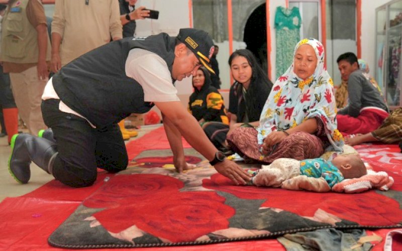 BAHTIAR MENYAPA. Pj Gubernur Sulsel, Bahtiar Baharuddin, menyapa seorang bayi didampingi ibunya, saat mengunjungi langsung Kabupaten Luwu, khususnya lokasi yang terkena bencana banjir dan tanah longsor, di Kecamatan Suli, Sabtu (5/5/2024), dini hari tadi. foto: istimewa