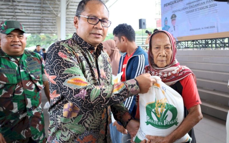 PENYERAHAN. Wali Kota Makassar, Moh Ramdhan Pomanto, menyerahkan Bantuan Pangan Beras Pemerintah Pusat melalui Badan Pangan Nasional Tahap II kepada Keluarga Penerima Manfaat (KPM) di Kota Makassar di Tribun Lapangan Karebosi Makassar, Jumat (14/6/2024). foto: istimewa