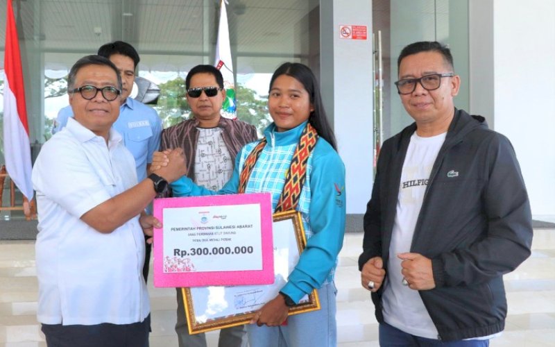 BONUS. Sekda Provinsi Sulbar Muhammad Idris menyerahkan bonus sebesar Rp300 juta kepada atlet dayung Sulbar Ramla Baharuddin, yang meraih dua medali perak pada PON XXI Aceh-Sumut 2024, Rabu (11/9/2024). foto: istimewa