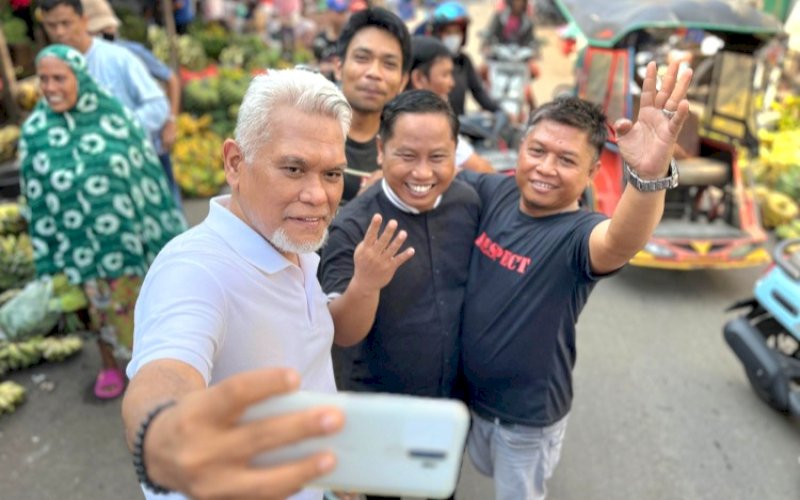 SAMBUTAN. Pedagang dan pengunjung Pasar Terong Makassar berebut foto dengan Calon Wali Kota Makassar Nomor Urut 4, Amri Arsyid, saat berkunjung ke Pasar Terong Makassar, Sabtu (19/10/2024). foto: istimewa