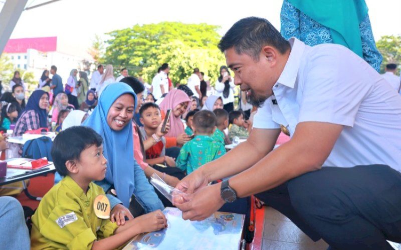 MAKAN TELUR. Pjs Wali Kota Makassar, Andi Arwin Azis, mengajak seorang anak makan telur pada acara Gerakan Makan Telur dan Lomba Mewarnai Dalam Rangka HUT Sulsel ke-355 di Lapangan Karebosi Makassar, Rabu (9/10/2024). foto: istimewa
