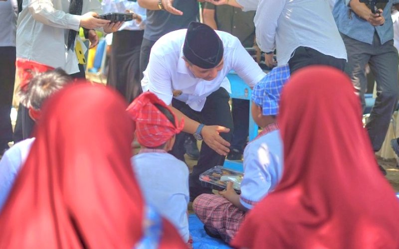 MAKAN BERGIZI. Pj Gubernur Sulbar, Bahtiar Baharuddin, secara simbolis menyerahkan makanan kepada salah seorang siswa pada saat menghadiri uji coba makan bergizi gratis di SDN 066 Pekkabata, Kabupaten Polman, Sulbar, Rabu (30/10/2024). foto: istimewa