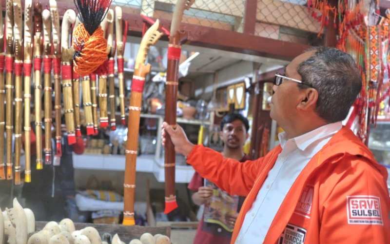 BLUSUKAN. Calon Gubernur Sulsel, Moh Ramdhan Pomanto, membeli parang Toraja saat blusukan ke Pasar Rakyat Bolu, Toraja Utara, Selasa (8/10/2024) pagi. foto: istimewa