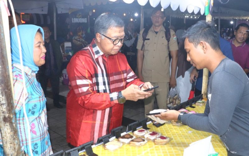 GEMA SULBAR. Sekda Provinsi Sulsel, Muhammad Idris, melakukan transaksi saat menghadiri pembukaan Gema Sulbar yang dilaksanakan Dinas Pariwisata Provinsi Sulbar di Anjungan Pantai Manakarra Mamuju, Sulbar, Senin (21/10/2024). foto: istimewa