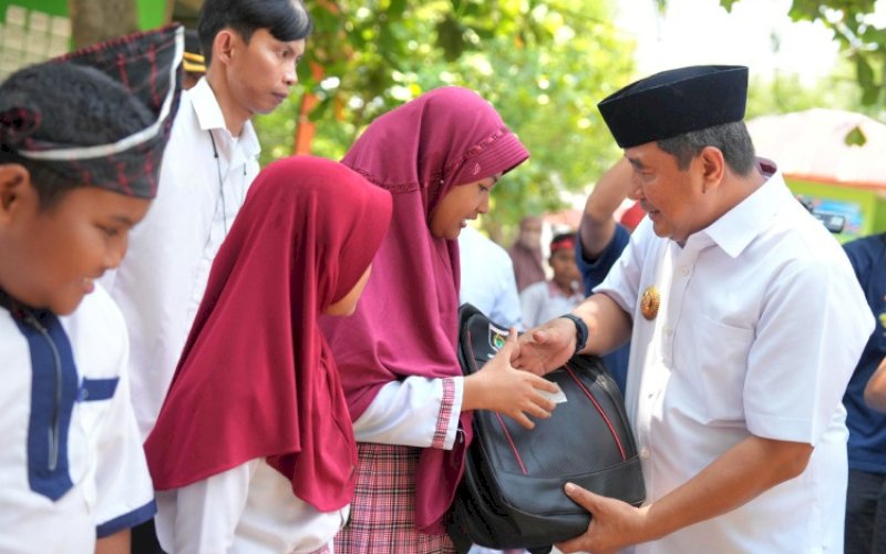 PEMBAGIAN. Pj Gubernur Sulbar, Bahtiar Baharuddin, membagikan perlengkapan sekolah kepada siswa SD di Sulbar, belum lama ini. Hal ini sejalan arahan Presiden RI Prabowo Subianto saat Deklarasi Gerakan Solidaritas Nasional (GSN), Minggu (3/11/2024). foto: istimewa