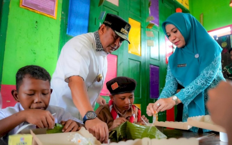 MENYAJIKAN. Pj Gubernur Sulbar Bahtiar Baharuddin bersama Pj Ketua Tim Penggerak PKK Provinsi Sulbar Sofha Marwah Bahtiar menyajikan makanan saat memantau jalannya program asta cita Presiden Prabowo Subianto di SDN 1 Pasangkayu, Senin (11/11/2024). foto: istimewa