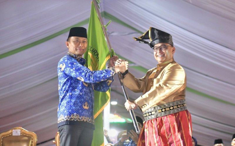 PENYERAHAN. Ketua Umum Korpri Nasional Zudan Arif Fakrulloh menyerahkan bendera pataka MTQ Korpri Nasional kepada Ketua Korpri Sulsel Hasan Sijaya sebagai simbol penunjukan Provinsi Sulsel sebagai tuan rumah MTQ VIII Korpri Nasional 2026 mendatang di sela-sela penutupan MTQ VII Korpri Nasional 2024 di halaman Kantor Gubernur Kalteng, Sabtu (9/11/2024) malam. foto: istimewa