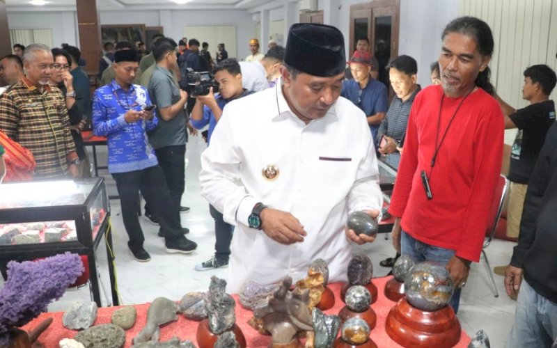 KEMILAU BATU. Pj Gubernur Sulbar, Bahtiar Baharuddin, mengatamati Batu Ngalo Manakarra di sela-sela membuka Kemilau Batu Ngalo Manakarra, yang akan berlangsung 13 sampai 15 Desember 2024 mendatang. foto: istimewa