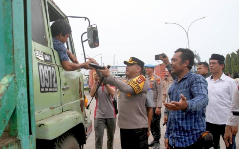 BERBAGI. Kapolres Pelabuhan Makassar, AKBP Restu Wijayanto, berbagi paket makan siang Jumat Berkah kepada sopir peti kemas dan pengendara jalan lainnya pada acara Jumat Curhat dan Jumat Berkah, Jumat (14/2/2025). foto: istimewa