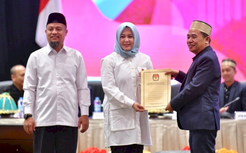 PENETAPAN. Ketua KPU Sulsel Hasbullah menyerahkan berkas hasil Rapat Pleno Terbuka Penetapan Pasangan Calon Gubernur dan Wakil Gubernur Terpilih Provinsi Sulsel 2024 yang digelar Komisi Pemilihan Umum (KPU) Provinsi Sulsel kepada pasangan Andi Sudirman Sulaiman dan Fatmawati Rusdi di Hotel Claro Makassar, Rabu (5/2/2025) malam. foto: istimewa