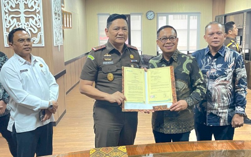 MOU. Executive Director 4 Pelindo Regional 4 Abdul Azis dan Kajati Kaltim Iman Wijaya memperlihatkan berkas Memorandum of Understanding (MoU) usai penandatanganan, Kamis (15/5/2025). foto: istimewa