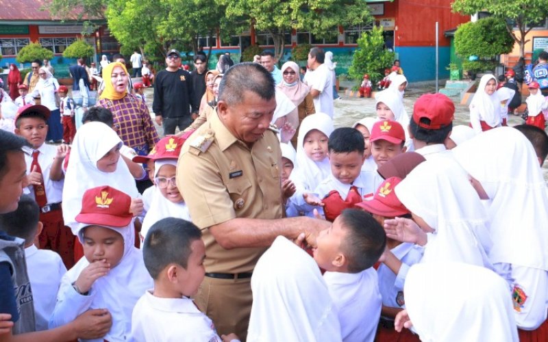 MENYAPA. Bupati Bulukumba, Andi Muchtar Ali Yusuf, menyapa dan menyalami anak sekolah di sela-sela meninjau pelaksanaan Gerakan Ayah Teladan Mengantar Anak di hari pertama sekolah di SD Negeri 2 Bulukumba, Senin (14/7/2025). foto: istimewa